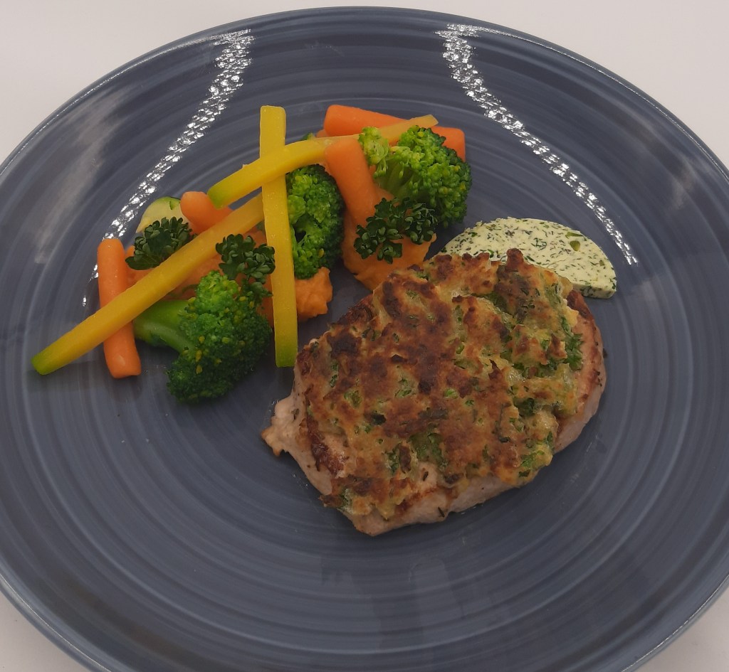 Gebratenes Schweinerückensteak mit Kräuterkruste und glaciertem Gemüse und Süßkartoffelpüree